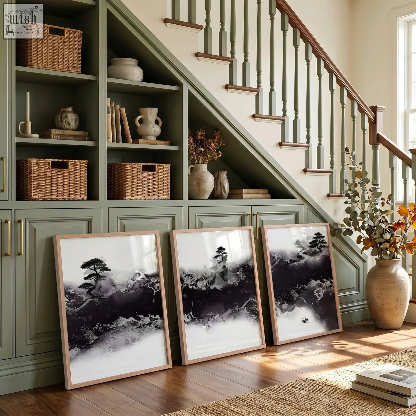 Three large japanese wall art prints in black and white ink with minimalist wooden frames lean against a green cabinet