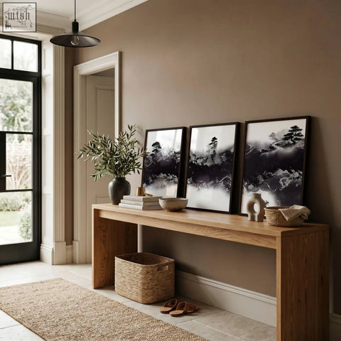 A minimalist wooden console table with a natural finish paired with large japanese wall art misty ink landscape set of 3