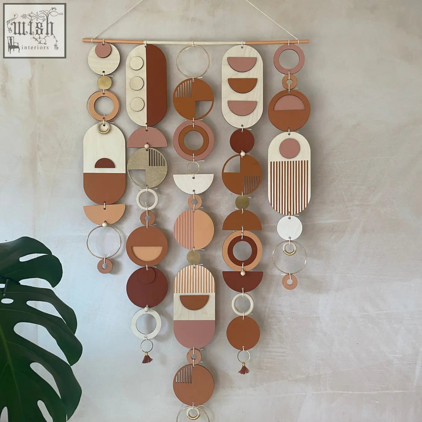 Large modern wall art featuring hand painted geometric wooden and metal circles in warm terracotta beige and cream tones