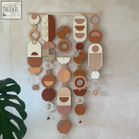 Large modern wall art featuring hand painted geometric wooden and metal circles in warm terracotta beige and cream tones