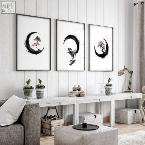 Three large black and white ink art prints with trees in enso circles displayed in living room frames
