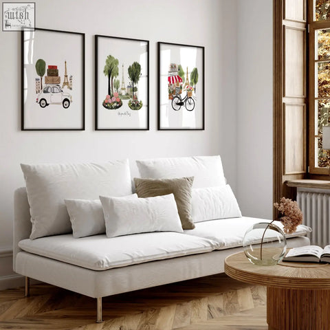 White upholstered sofa with metallic legs and cushions in living room featuring eiffel tower travel wall art set of 3