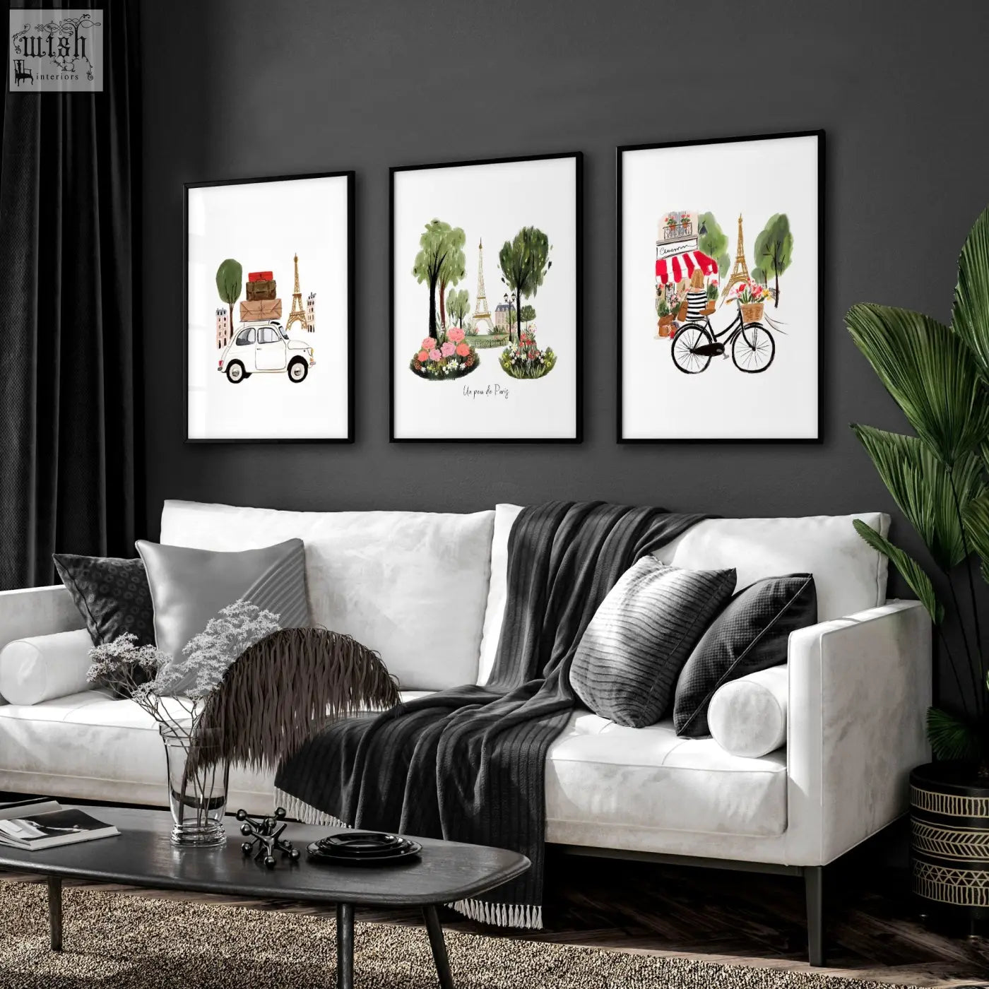 White sofa with black and gray pillows and dark gray blanket in living room with eiffel tower travel wall art prints