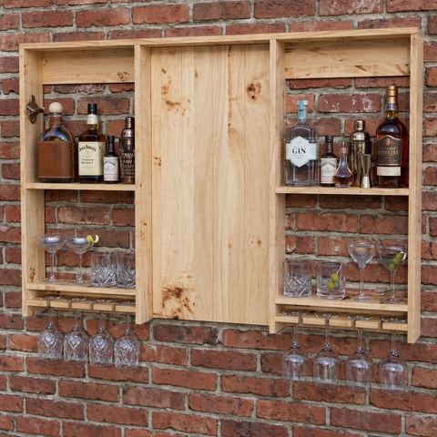 Large rustic wooden bar shelving unit with light wood, sliding door, open shelves, and glassware racks for garden bar setup