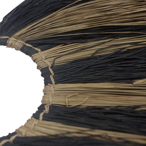 Large seagrass fan wall decor with black and tan woven natural fiber bristles for stylish wall decor