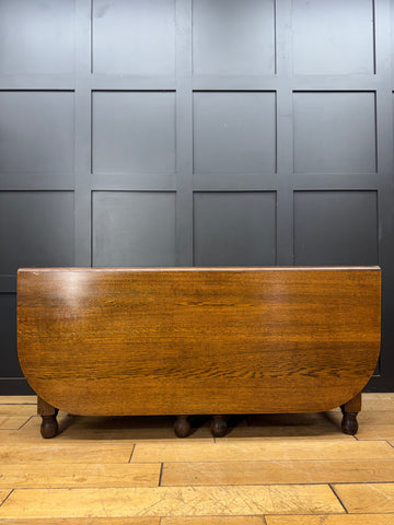Antique large solid oak gateleg dining table with drop leaf and turned wooden legs in warm finish