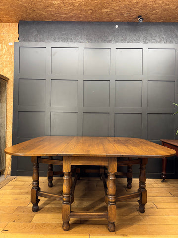 Large solid oak gateleg dining table with drop leaf and turned legs in warm rich wood finish perfect for kitchen or dining room