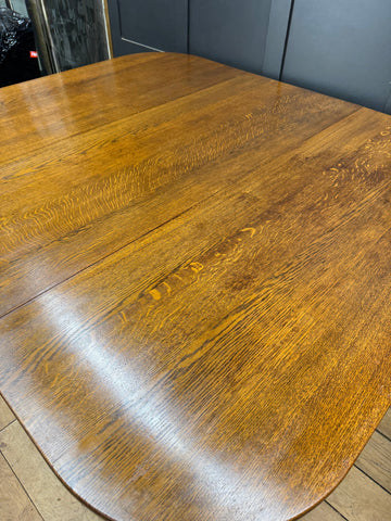 Large solid oak gateleg dining table in rich amber finish with smooth polished surface and visible wood grain
