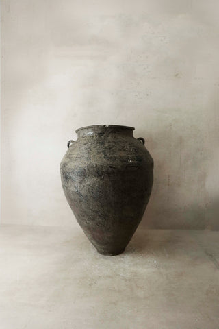 Antique dark gray metallic urn with textured surface and loop handles next to large vintage brown glazed ceramic pot as3