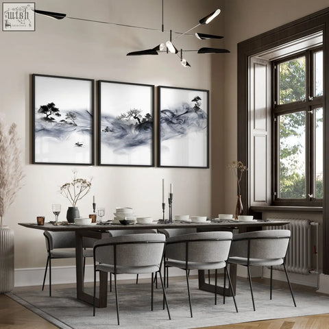 Three framed black-and-white ink wash landscape wall art prints hang above a dining room table in japandi style