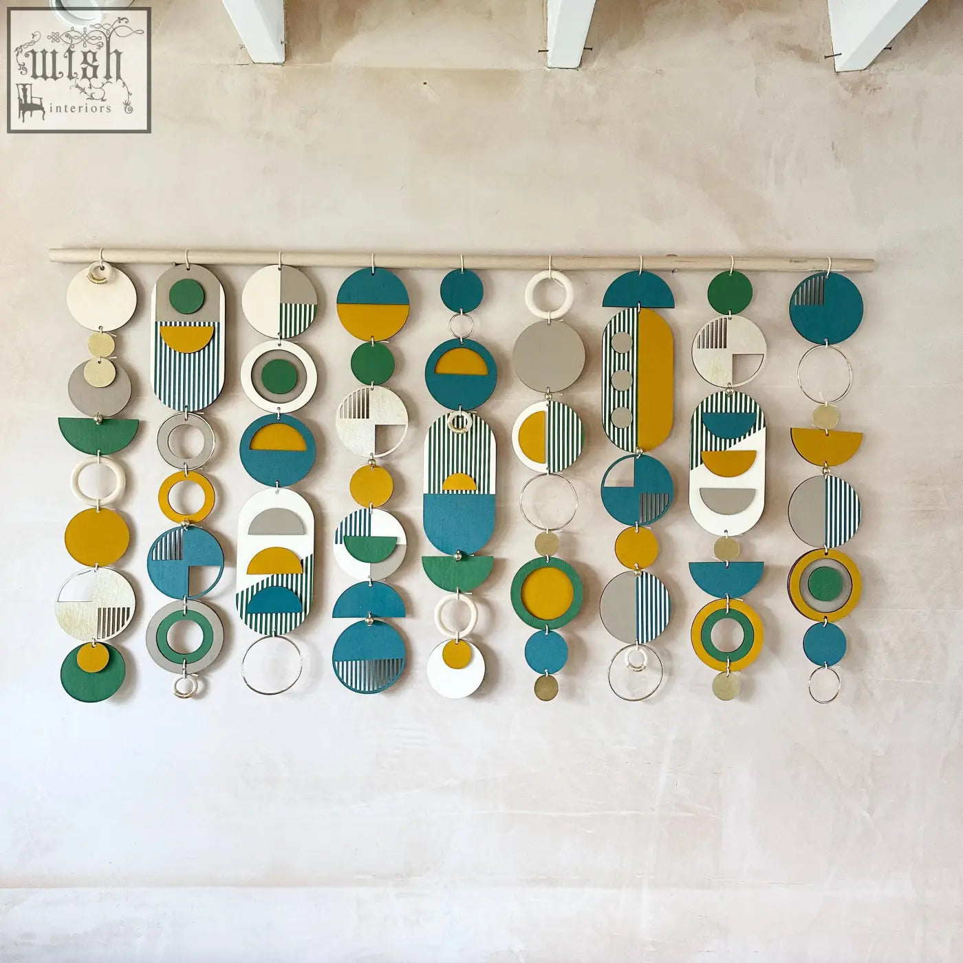 Large wall art wood piece with geometric layered circles in teal mustard yellow white gray and green for over the bed decor