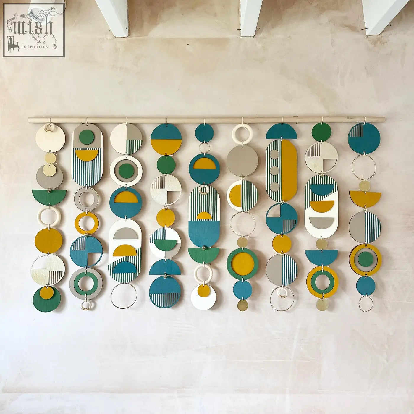 Large wall art with teal, mustard, green, white, and gray layered circles and ovals in geometric wood design for over the bed decor