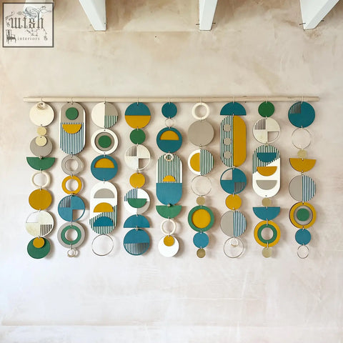 Large wall art with teal, mustard, green, white, and gray layered circles and ovals in geometric wood design for over the bed decor