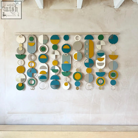 Large wall art with modern geometric pattern in teal, mustard, green, white, and gray wood for over the bed decor