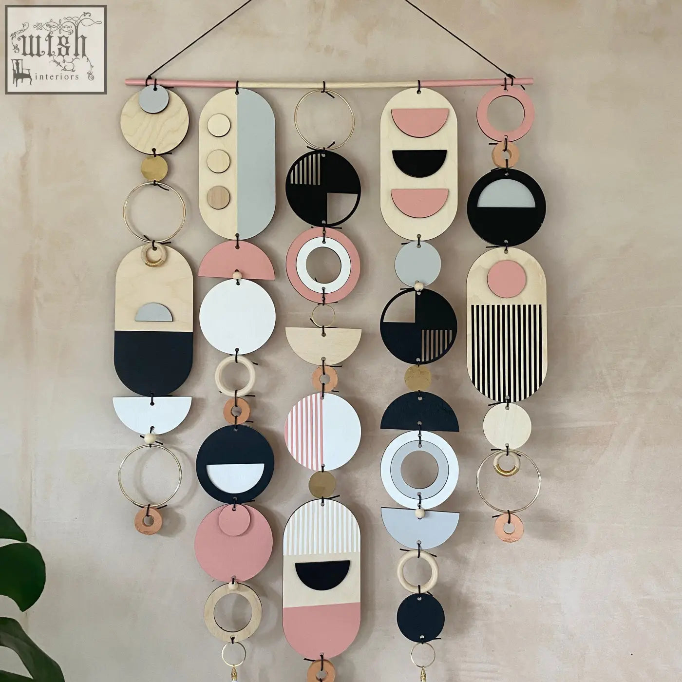 Large wall art featuring hand painted pink geometric wooden and metal shapes in pastel tones for minimal decor