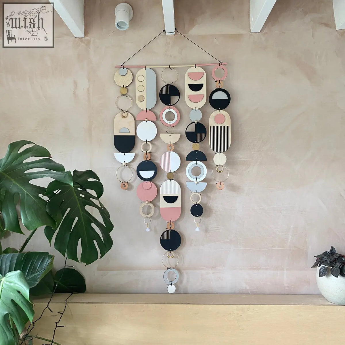 Large wall art featuring pink geometric hand painted wooden and metal pieces for minimal home decor