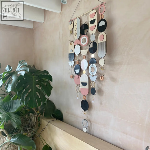 Large wall art featuring hand painted pink geometric wooden and metal shapes for minimal contemporary decor