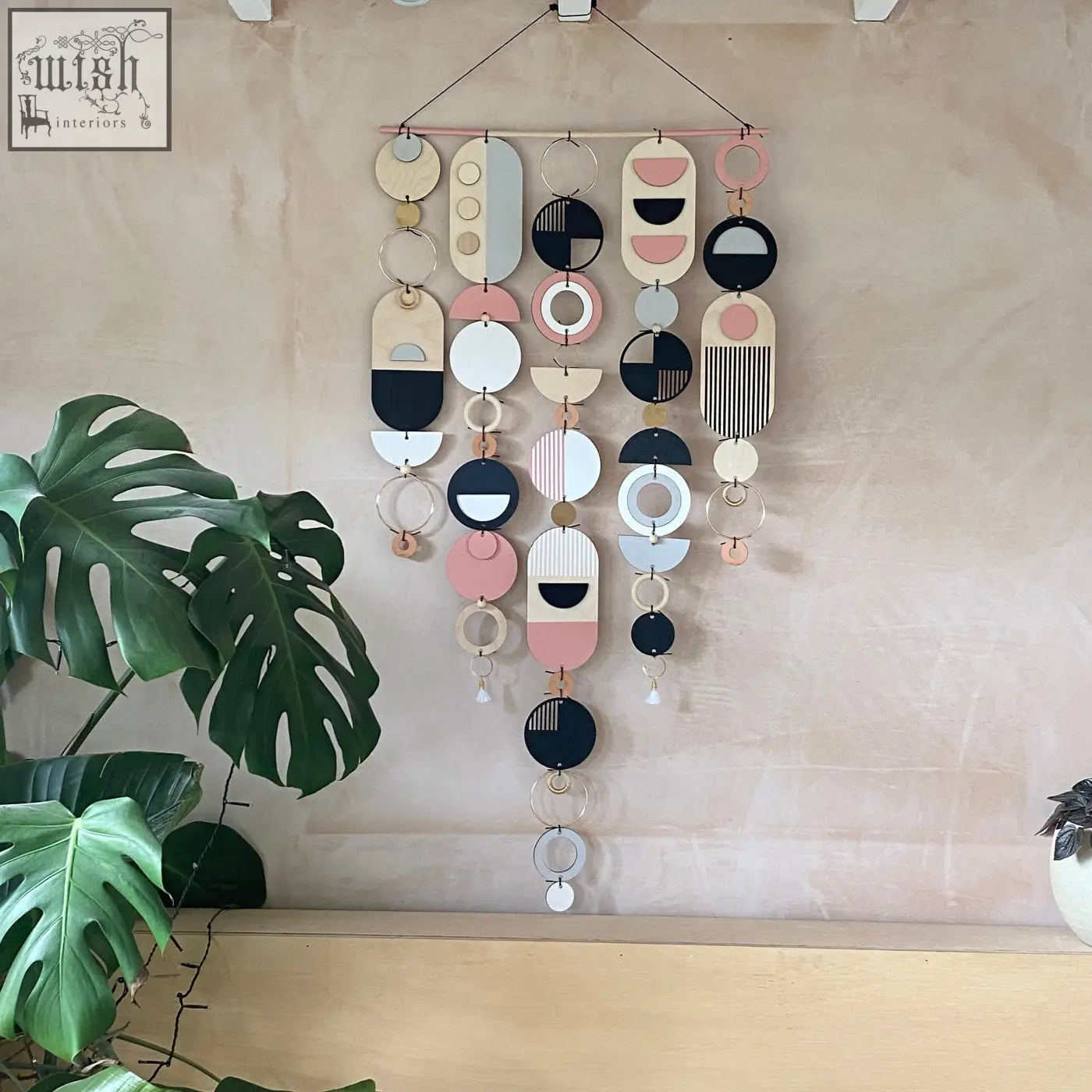 Large wall art featuring hand painted geometric wooden shapes in pink black white and natural tones for minimal decor
