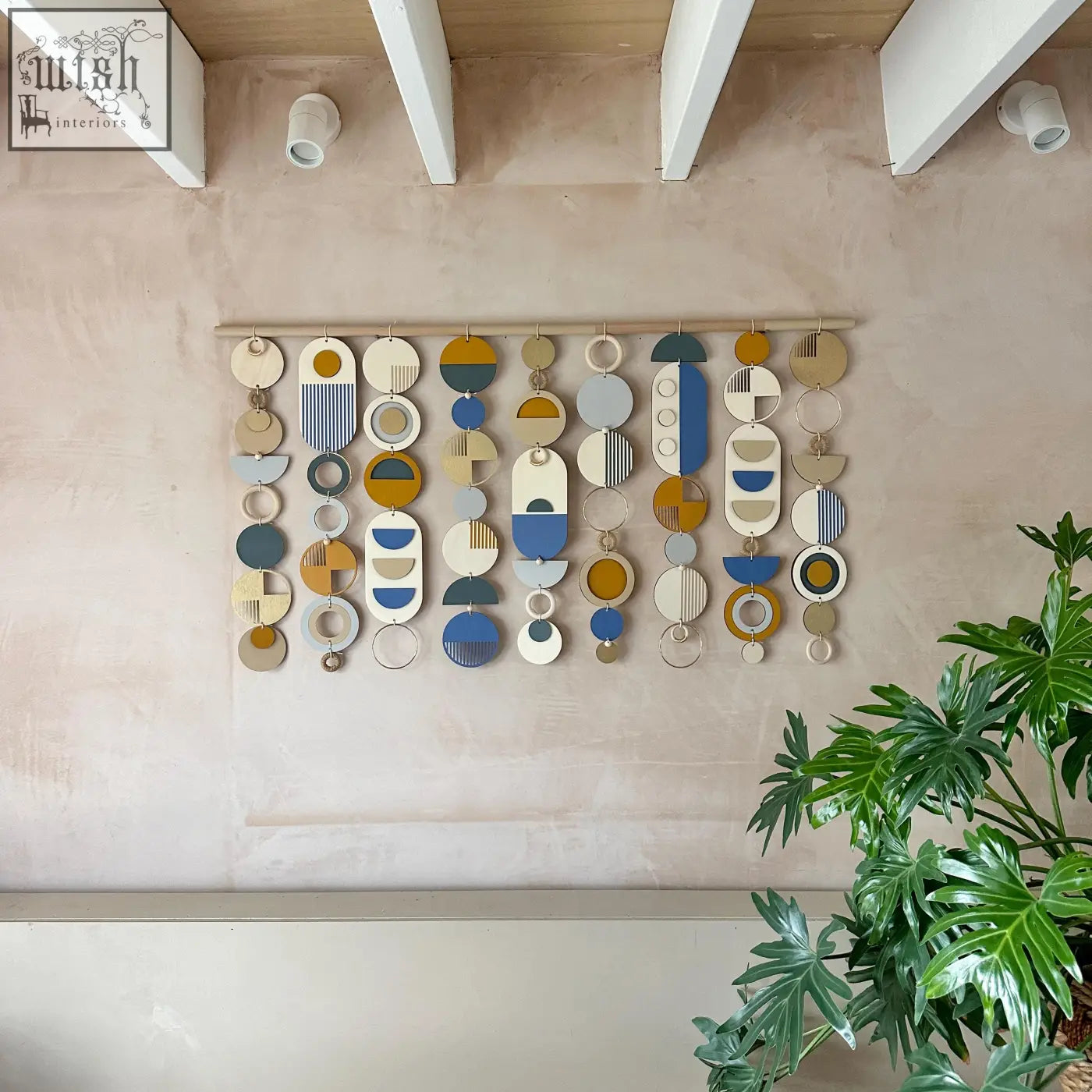 Large wood wall hanging with geometric layered circles in muted blues ochres creams and greys for modern wall decor
