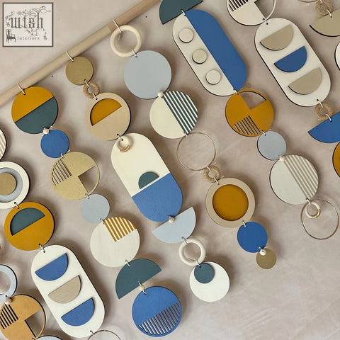 Large wood wall hanging with colorful geometric wooden shapes in blue yellow beige and white for modern wall decor
