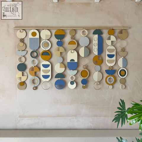 Large wood wall hanging with geometric layered circles in muted blues ochres creams and greys for modern wall decor