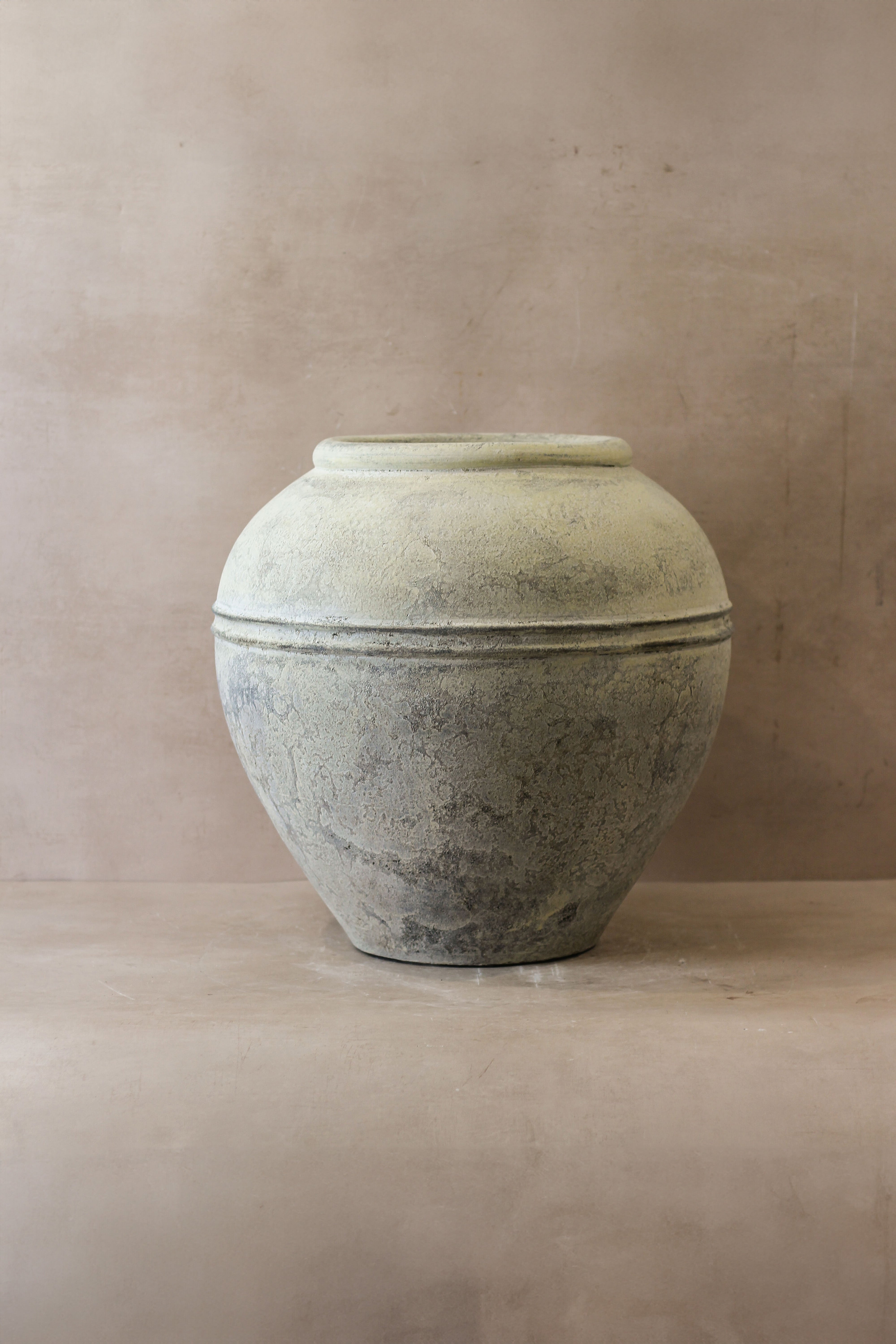 Large white rustic indonesian ceramic pot with rounded body and subtle horizontal ridges in light gray color