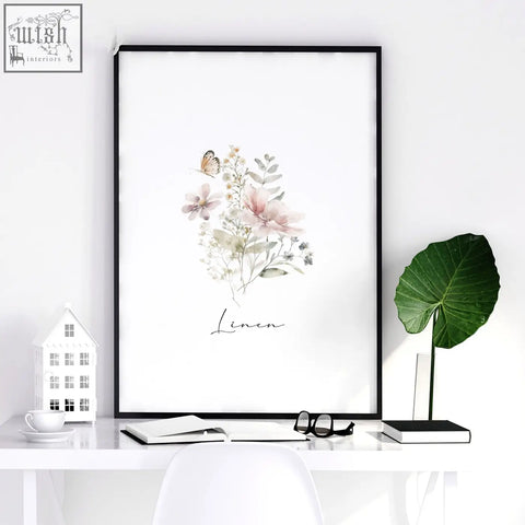 A framed watercolor laundry room poster with delicate pink and pale green flowers and a butterfly on white background