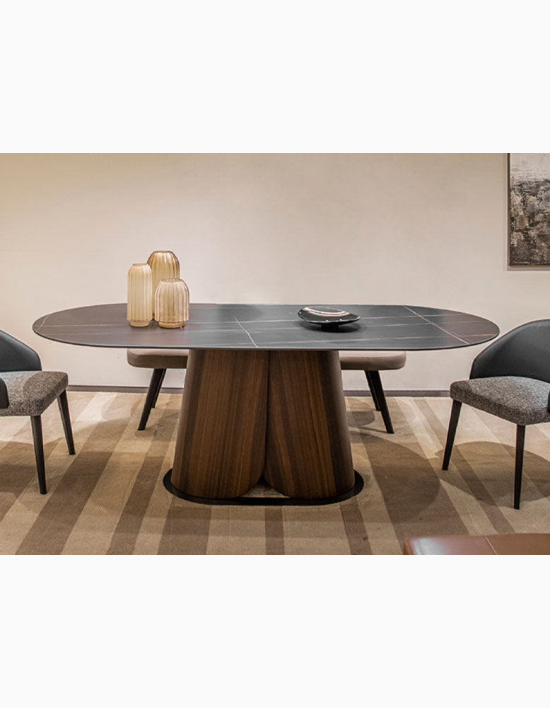 Elegant lauren dining table with a dark sintered stone oval top and sculpted wooden base perfect for dining rooms