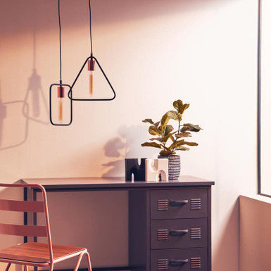 Lavis black geometric pendant light with copper finish and exposed filament bulbs hanging above dark wooden desk