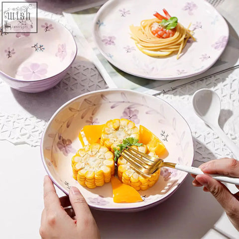 A delicate lavender ceramic bowl with floral pattern holding steamed corn and orange slices from layla orchid dining set