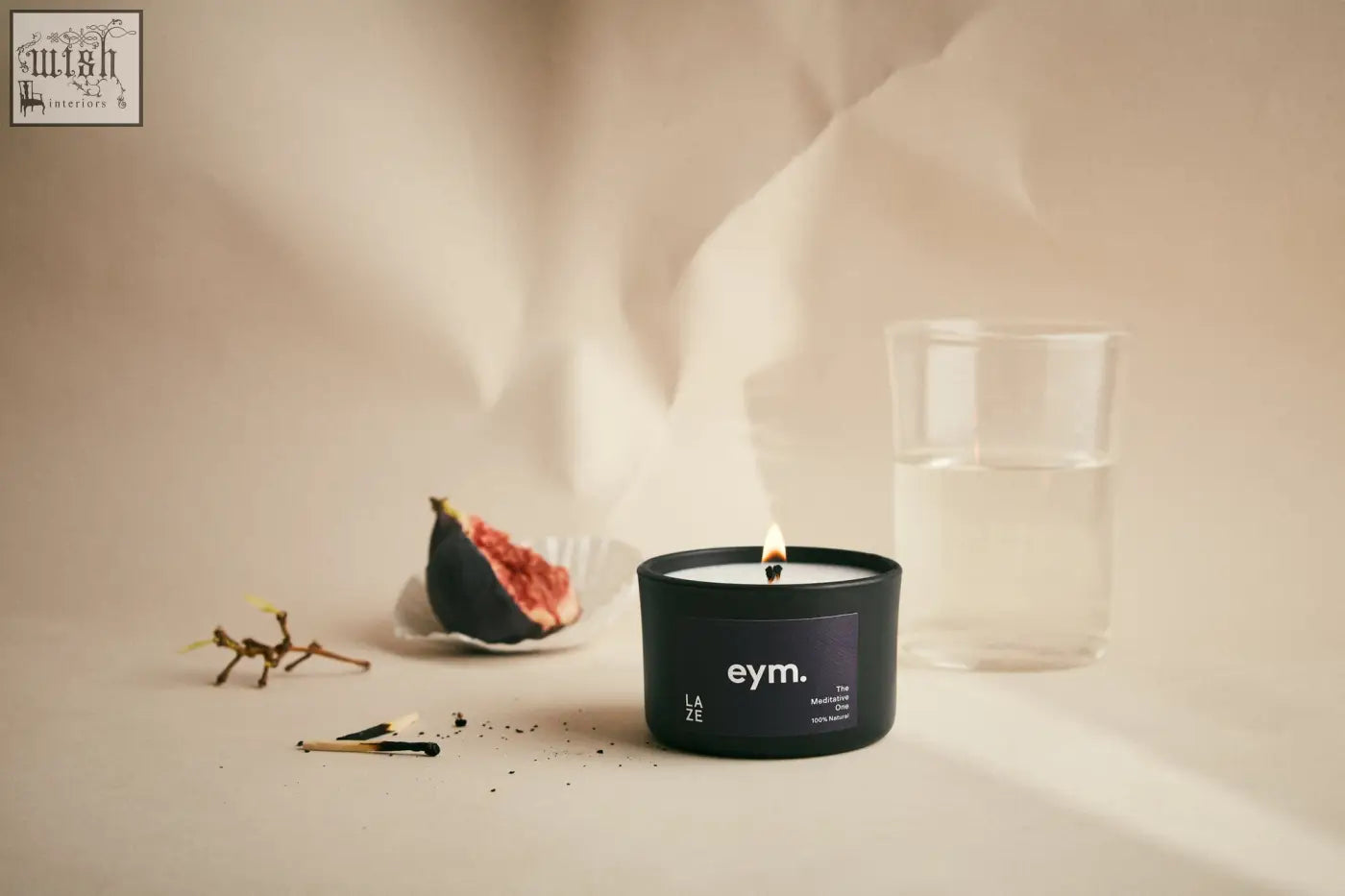 Black cylindrical mini candle laze with minimalist eym label and the bitter text in sleek matte container