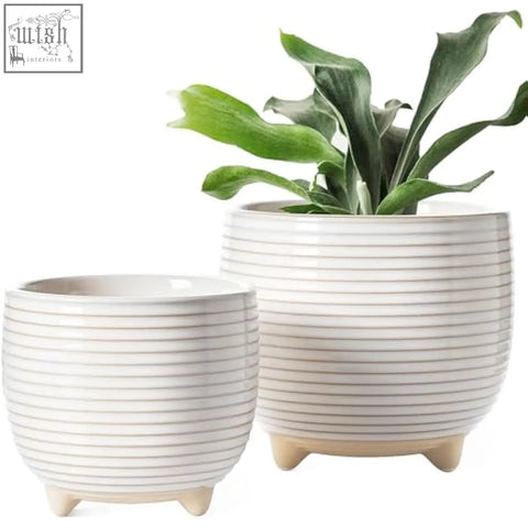 Cream-colored ceramic plant pots with horizontal ridges and three-legged bases perfect for indoor use
