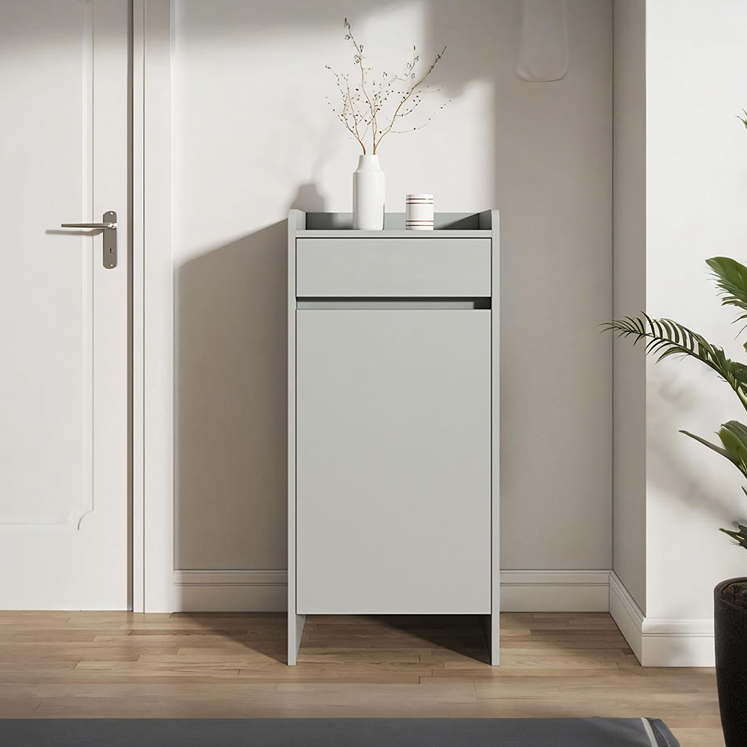 Minimalist gray leach shoe storage cabinet with small drawer and white vase holding dried branches on top