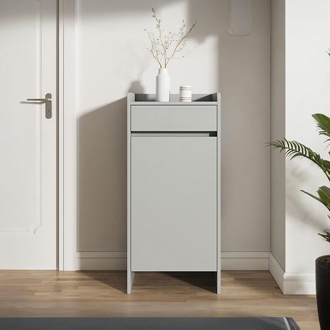 Minimalist gray leach shoe storage cabinet with small drawer and white vase holding dried branches on top