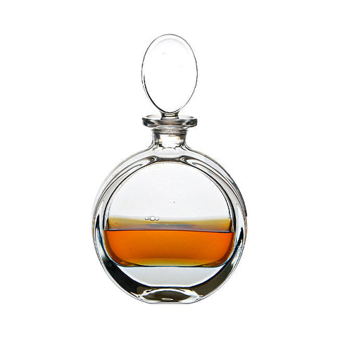 Clear glass lead crystal round spirit decanter with rounded body oval stopper and amber liquid inside 0.65ltr