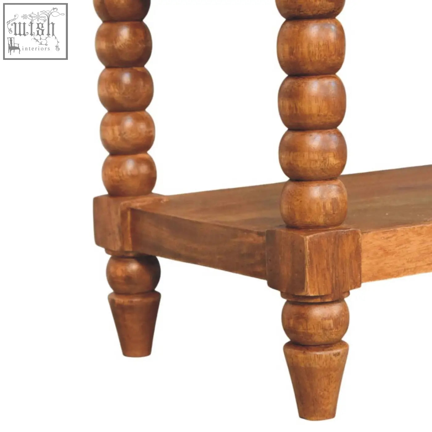 A rustic wooden two-tier side table with turned spool legs and warm natural finish complements a leather spindle bench