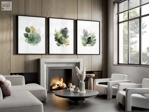 Three prints of leaves print wall art in warm gold-toned green watercolor style with sleek black frames on white backgrounds