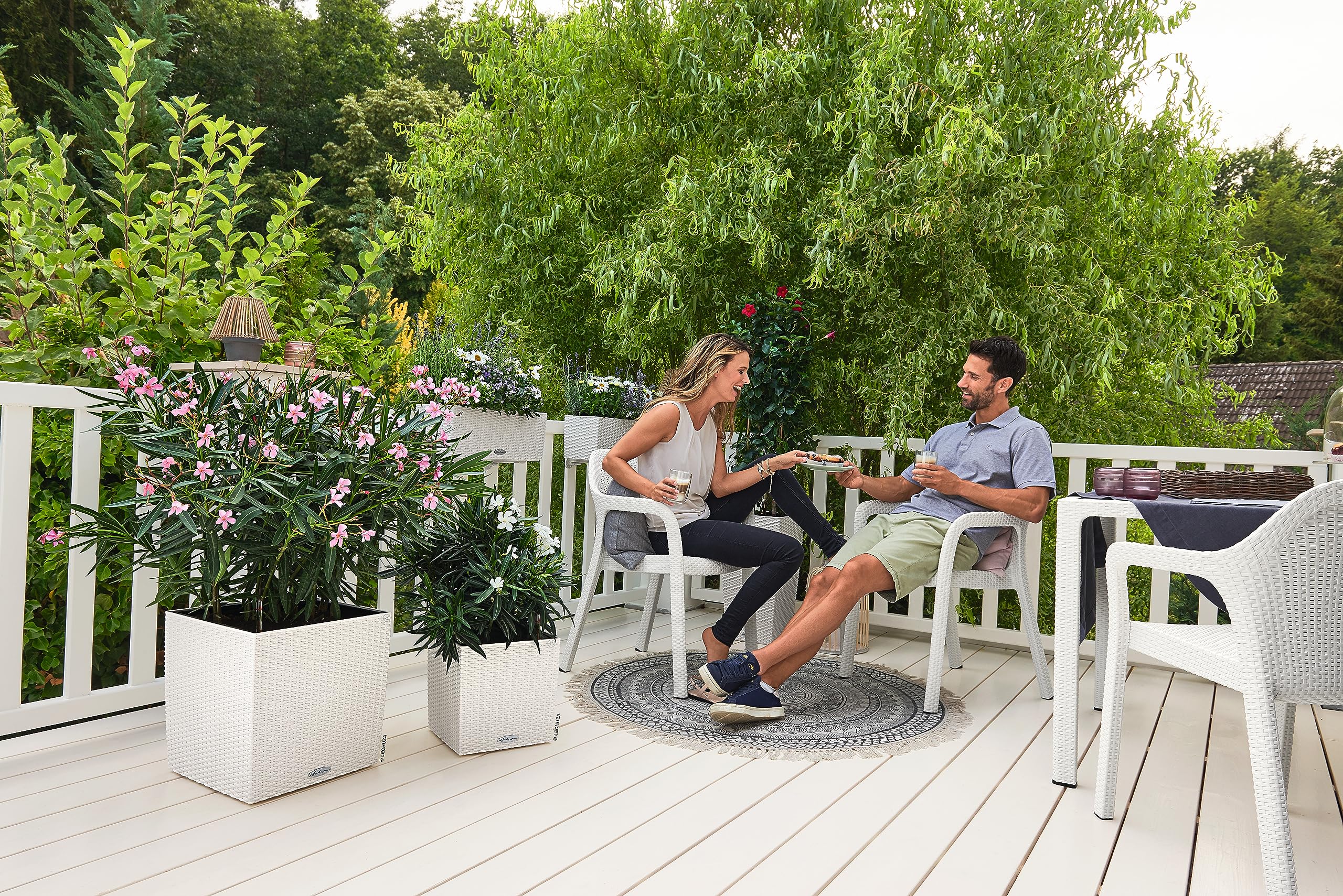 White woven resin patio chairs next to lechuza self watering plant pots cube cottage 40 rattan look planter