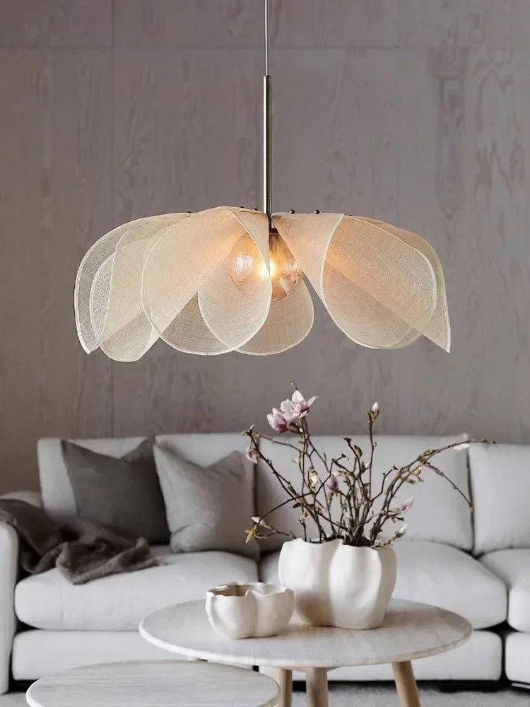 A cream-colored led flower pendant light with translucent petal shades hanging from a slim metallic rod for living room