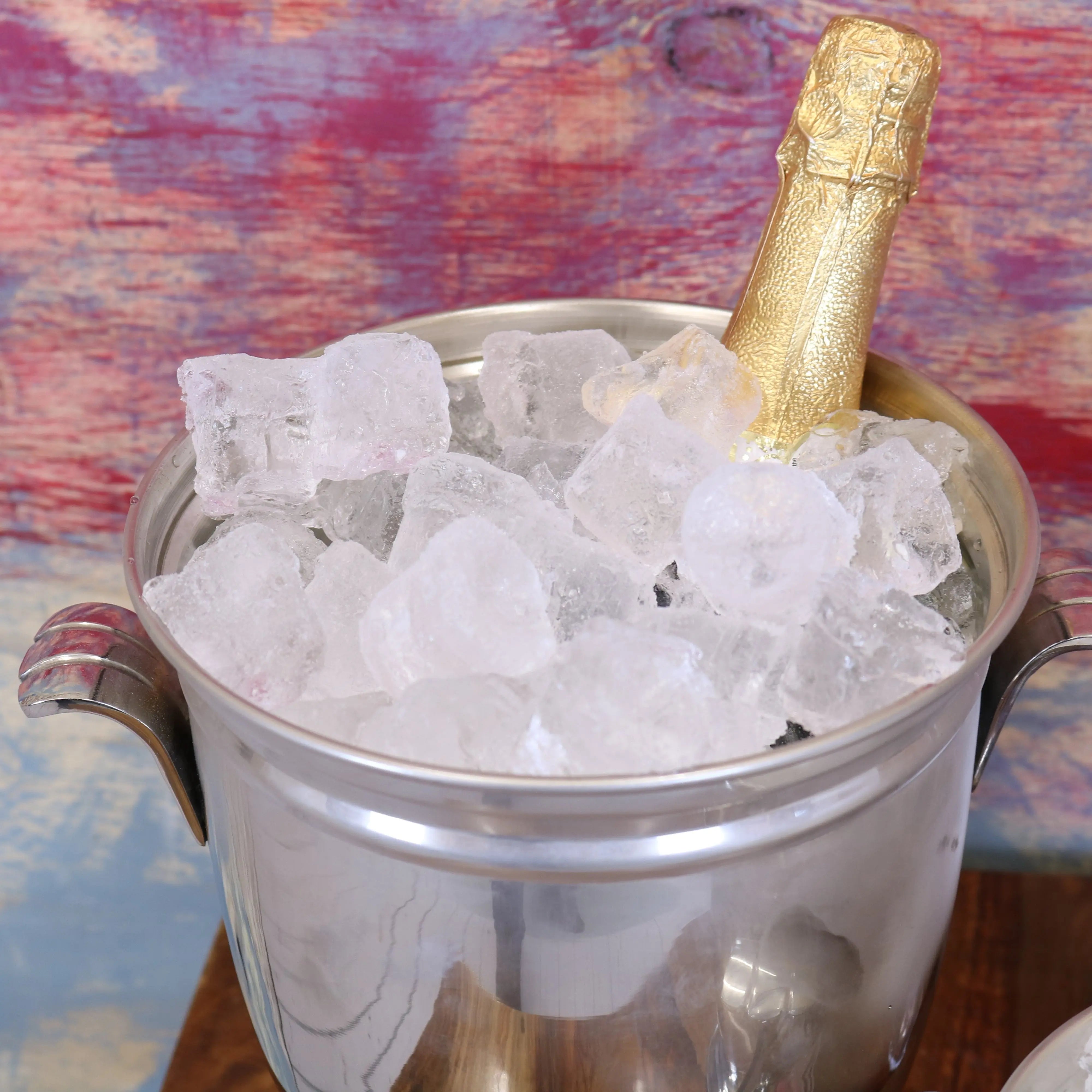 Lehal champagne bucket set with gold champagne bottle in silver ice bucket filled with clear chunky ice cubes