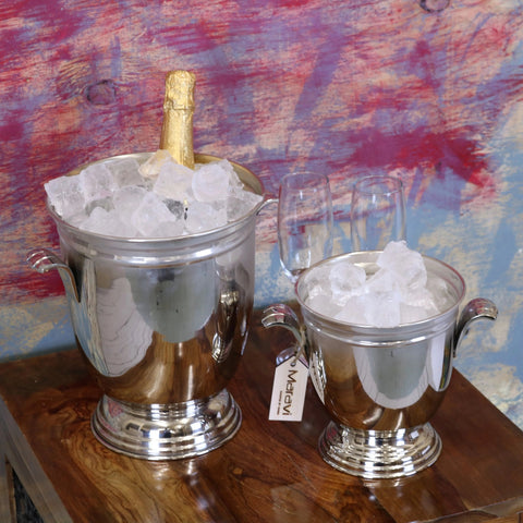 Shiny silver lehal champagne bucket with handles and fluted base filled with ice holding a sparkling wine bottle