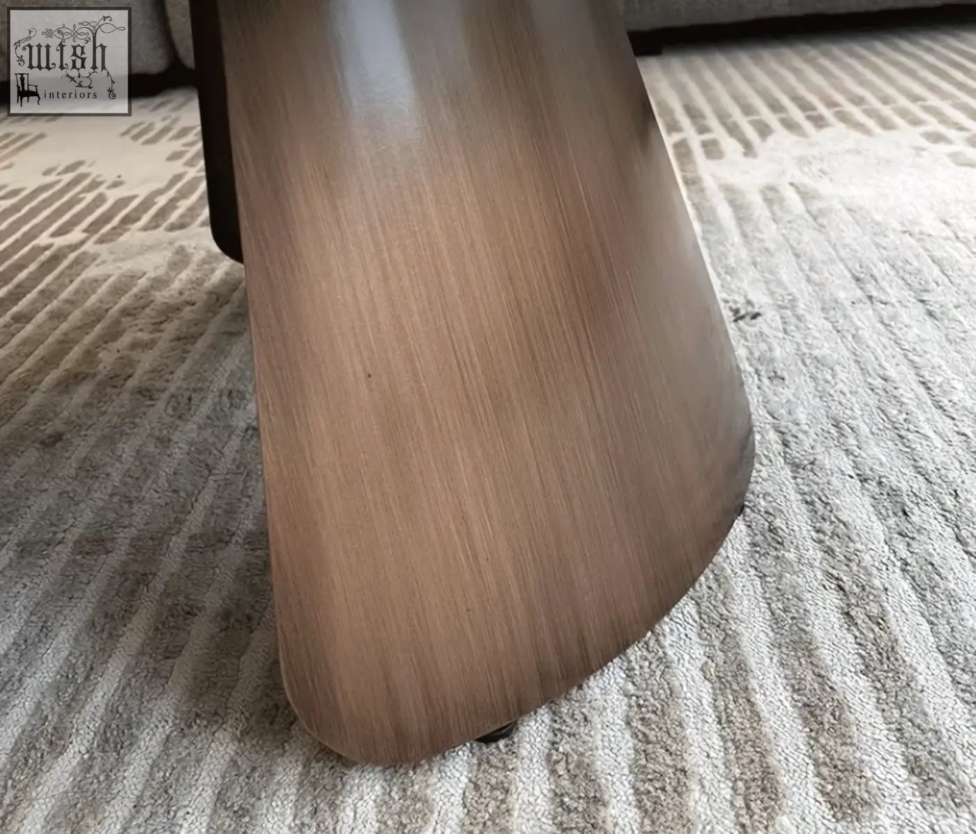Sleek tapered wooden leg of the leonor nesting coffee table with steel base in medium brown finish visible wood grain