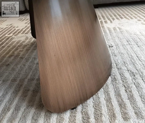 Sleek tapered wooden leg of the leonor nesting coffee table with steel base in medium brown finish visible wood grain