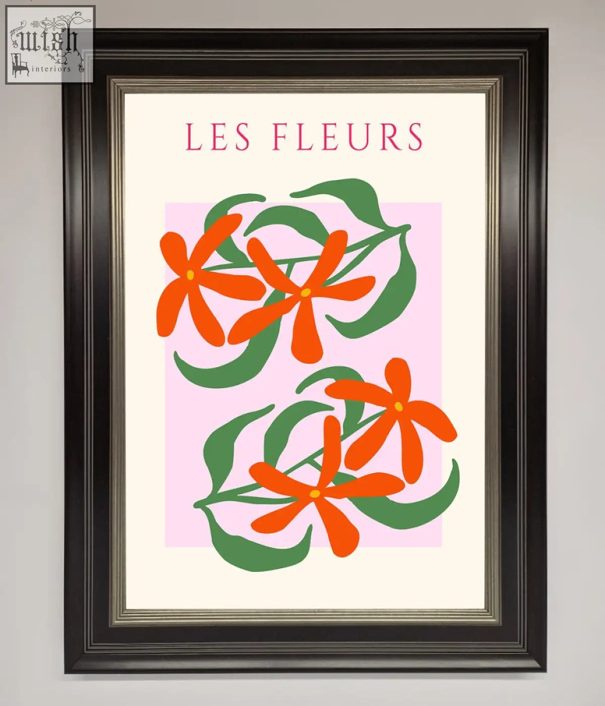 A les fleurs framed print featuring stylized orange flowers with green leaves on a soft pink background in a black frame