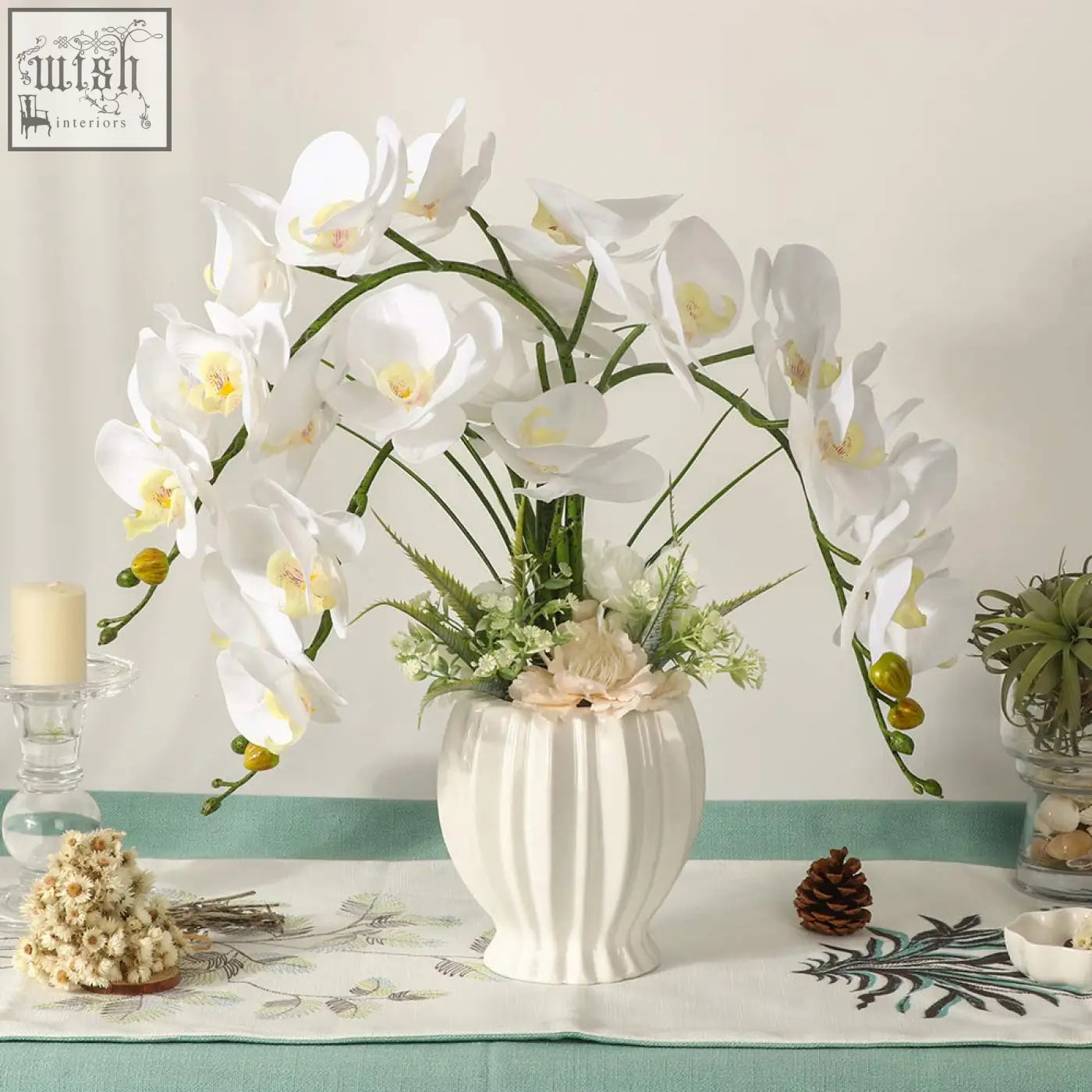 White ceramic vase with vertical ridges holding lesing artificial flowers ochids for indoor decor