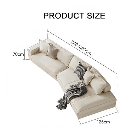 Beige lester four seater curved sofa with plush cushions and gray throw blanket draped over one end