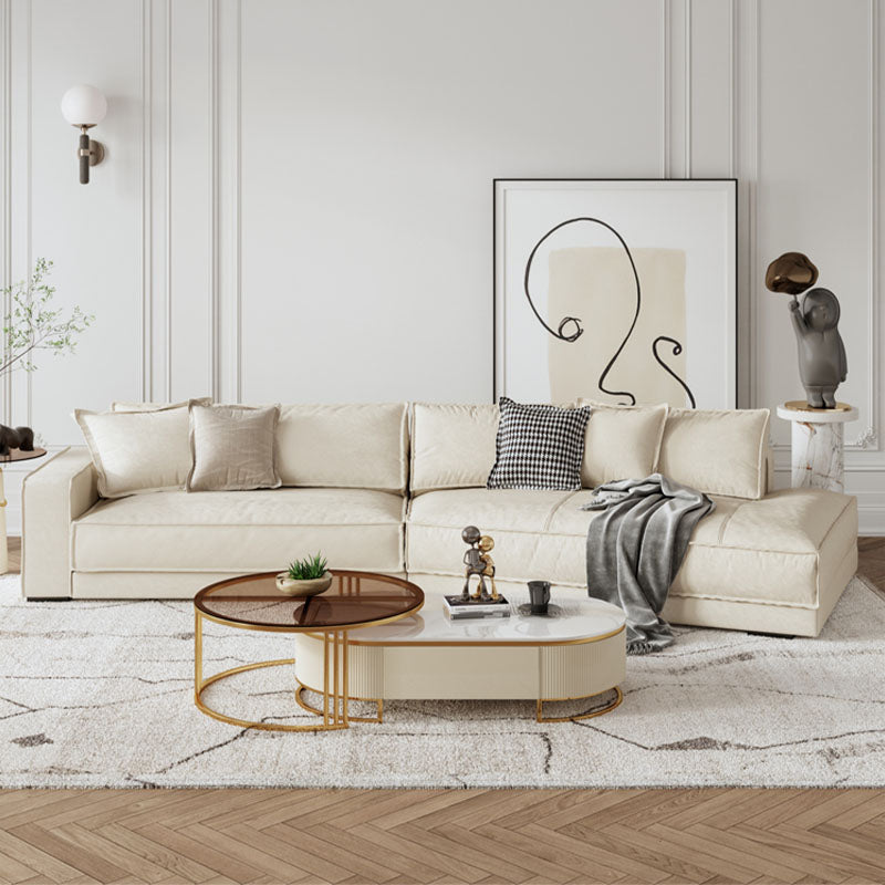Cream-colored curved four seater sofa with plush cushions and modern minimalist design for comfortable seating