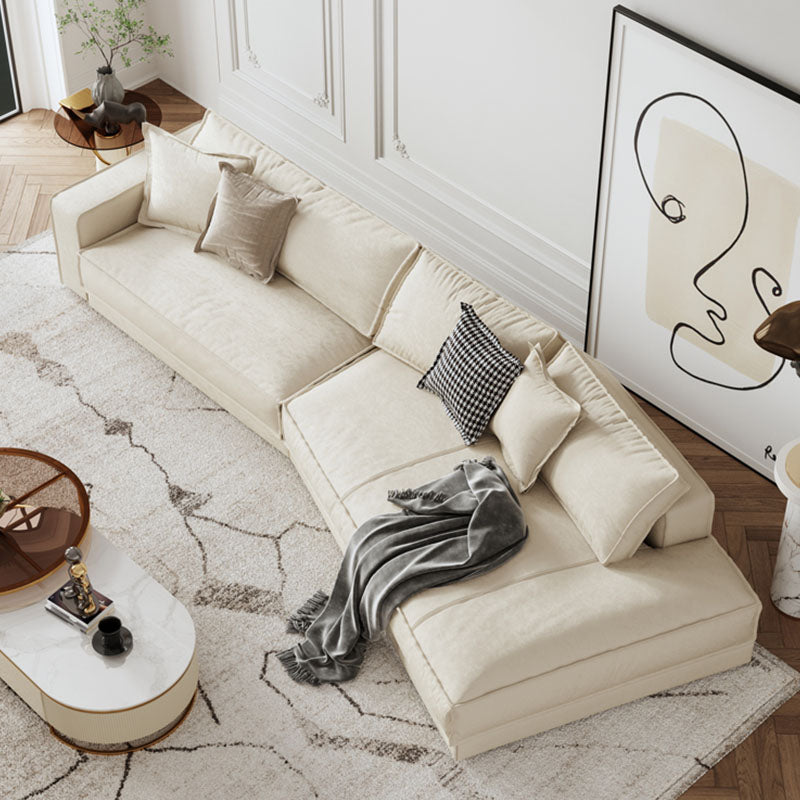 Cream-colored lester curved seater sofa with plush cushions and soft velvety texture perfect for living rooms