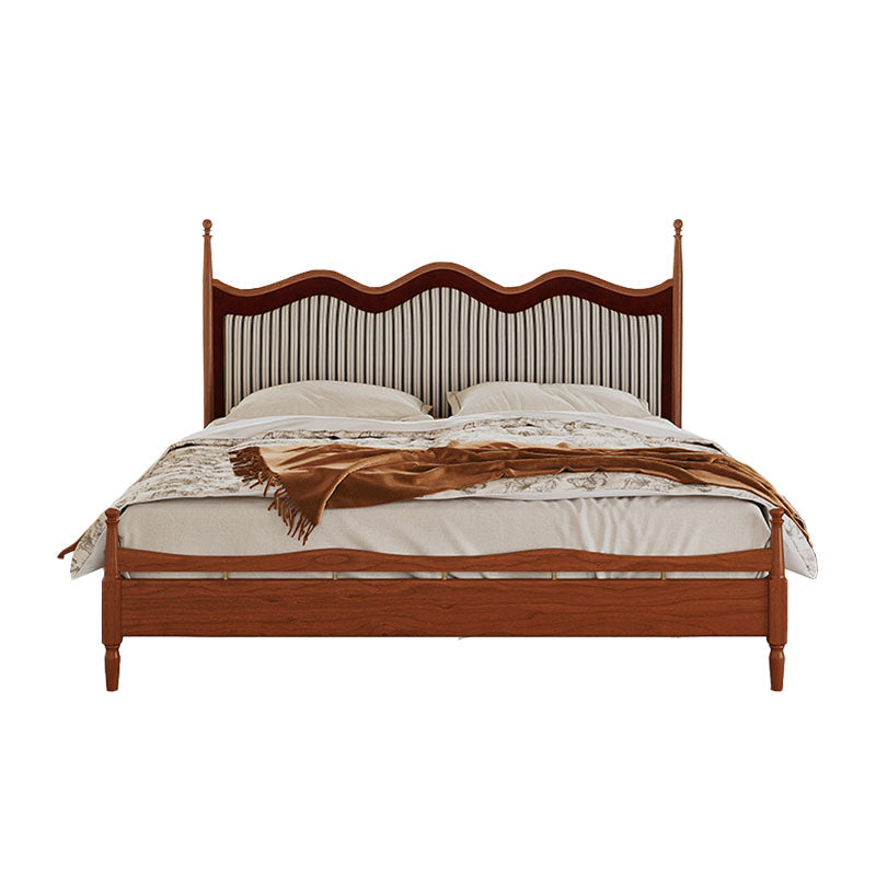 Liam super king size bed with a classic wooden frame and striped fabric curved headboard in warm polished wood