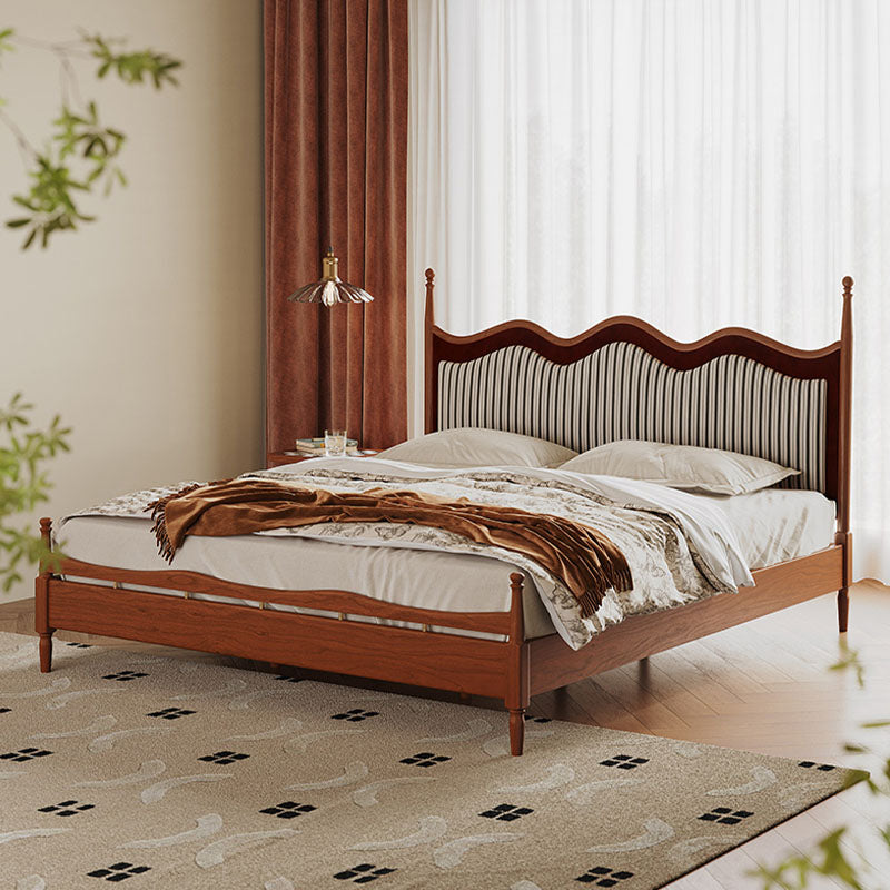 Liam super king wooden bed with curved striped upholstered headboard and footboard dressed in white linens and brown throw